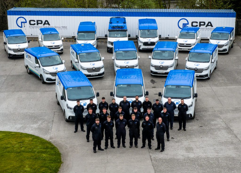 Team of engineers standing in front of vans
